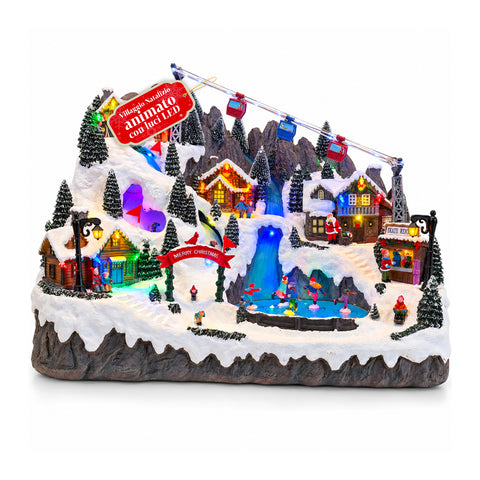 Pueblo navideño luminoso con pistas de esquí y patinaje en movimiento, luces LED y música – 56x37x42 cm